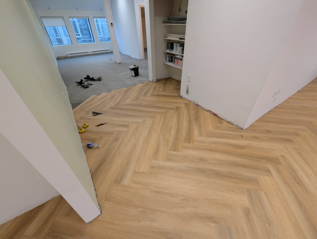 Lattes de vinyle collées installation herringbone - Bureau administratif à Longueuil.
